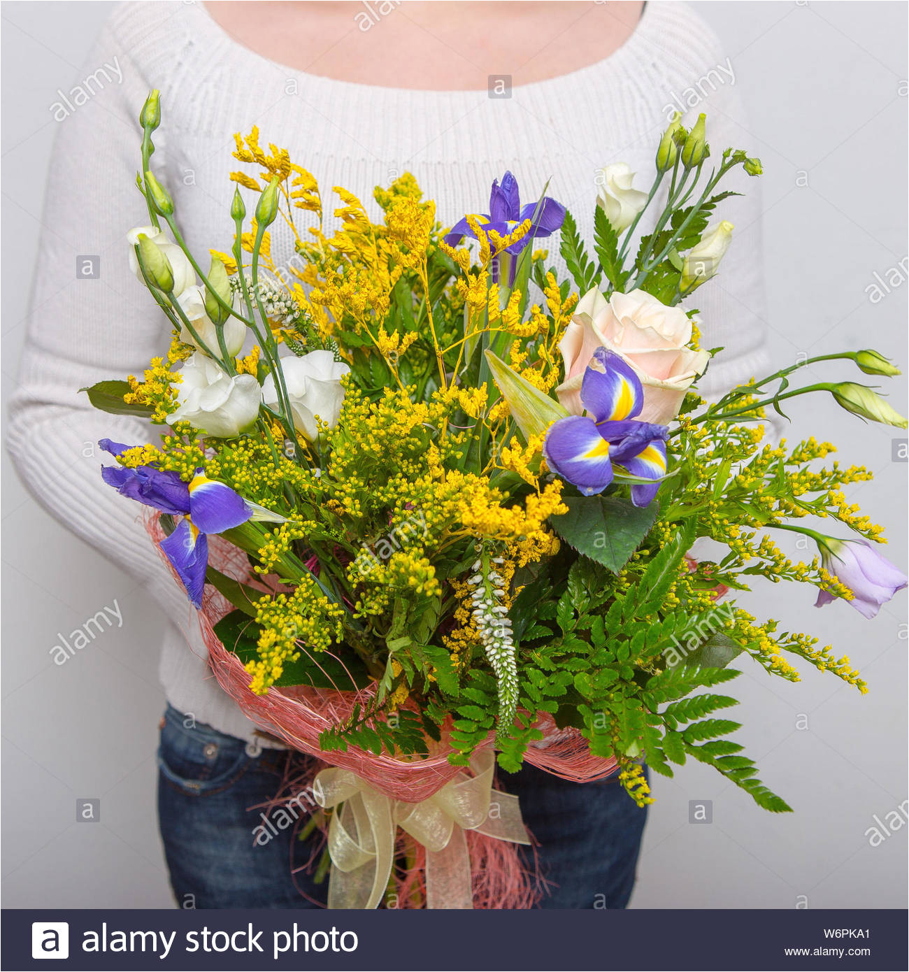 very nice florist woman holding a beautiful colourful blossoming flower bouquet leaves on white wall background w6pka1 jpg