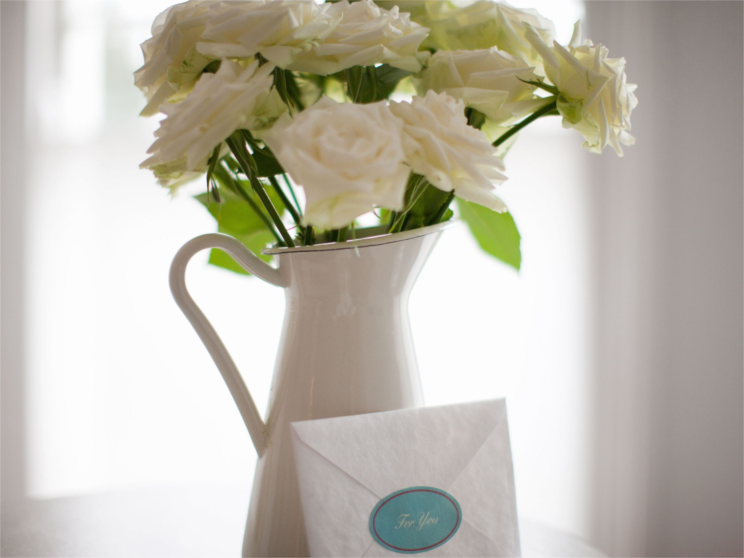 card leaning against white rose bouquet in pitcher 168683856 58d9361e3df78c5162d6ea1b jpg